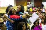 A proud mother hugs her daughter for graduating