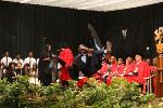 An ecstatic graduate celebrates his success onstage